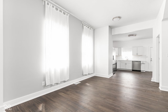 unfurnished living room featuring sink and dark hardwood / wood-style flooring