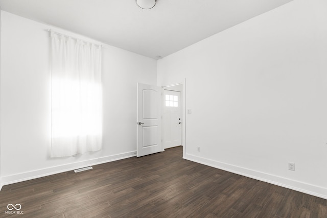 unfurnished room with dark wood-type flooring