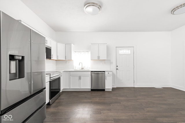 kitchen with sink, white cabinetry, stainless steel appliances, backsplash, and dark hardwood / wood-style flooring