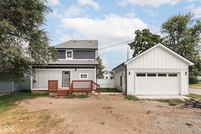 back of property with a deck and a garage