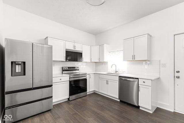 kitchen with white cabinets, backsplash, stainless steel appliances, dark hardwood / wood-style floors, and sink