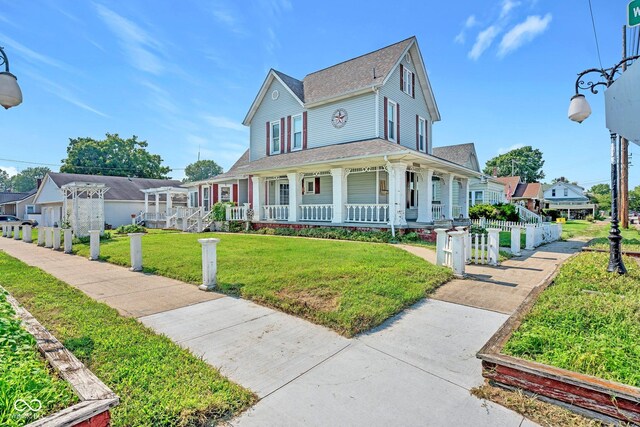 view of front facade with a front yard and covered porch