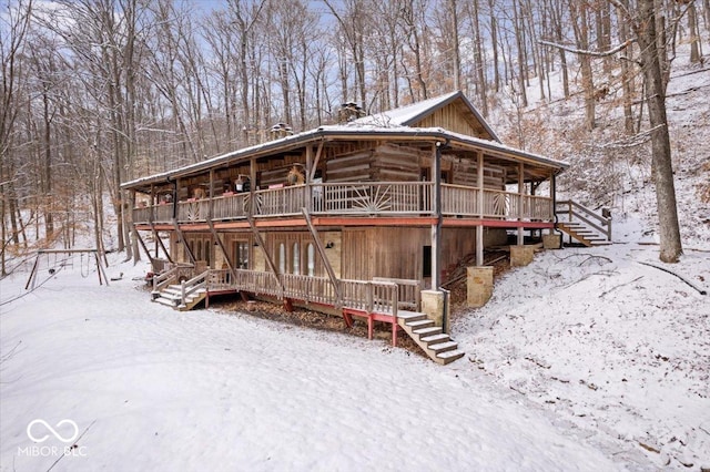 cabin with a deck, log exterior, and stairway