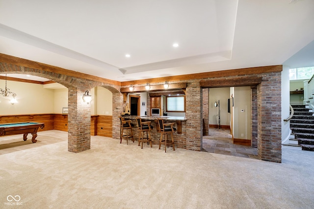 kitchen featuring carpet floors, wooden walls, and pool table