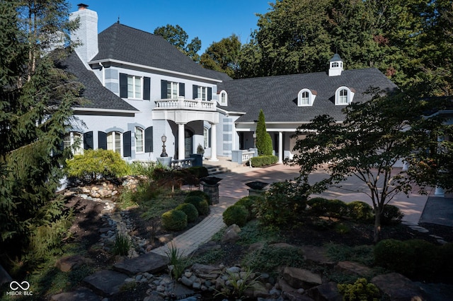 8358 Hidden Point Dr, Indianapolis, IN 46256 - view of front of house with a balcony, a shingled roof, and a chimney
