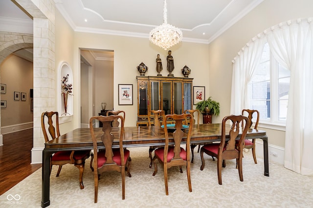 dining space featuring light hardwood / wood-style flooring, a notable chandelier, and ornamental molding