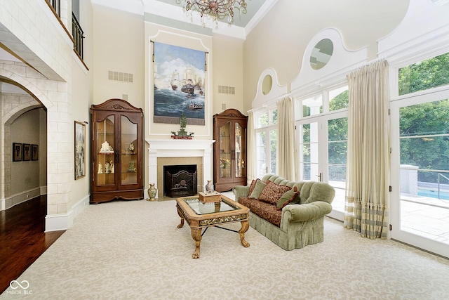 8358 Hidden Point Dr, Indianapolis, IN 46256 - living room featuring a fireplace with flush hearth, a high ceiling, healthy amount of natural light, ornamental molding, and wood finished floors