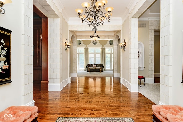 corridor featuring a chandelier, hardwood / wood-style flooring, and ornamental molding