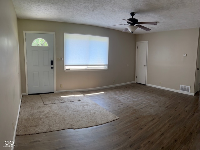 foyer featuring ceiling fan, wood-type flooring, and a textured ceiling