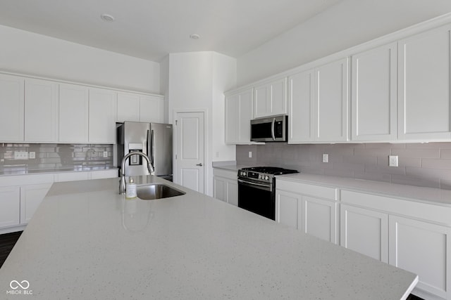 kitchen with white cabinets, sink, stainless steel appliances, and tasteful backsplash