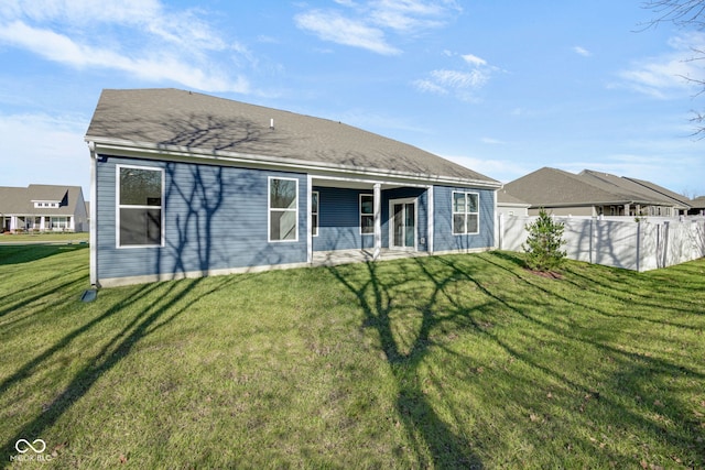 rear view of property featuring a lawn