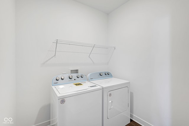 clothes washing area featuring dark wood-type flooring and washing machine and clothes dryer