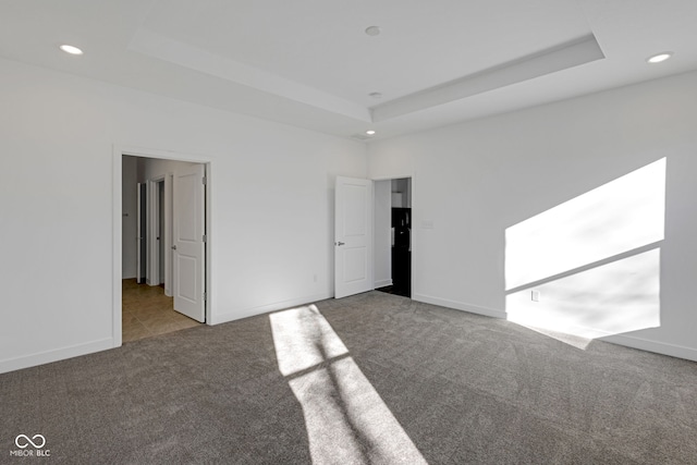 unfurnished bedroom with a tray ceiling and light colored carpet