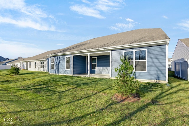 rear view of property featuring a lawn