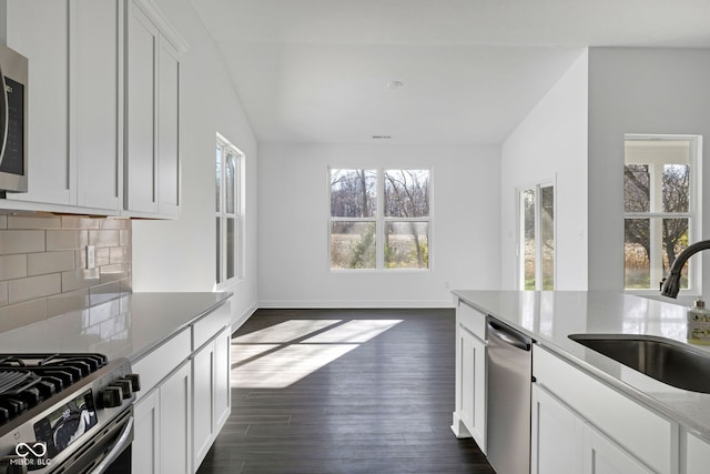 kitchen with appliances with stainless steel finishes, white cabinetry, plenty of natural light, and sink