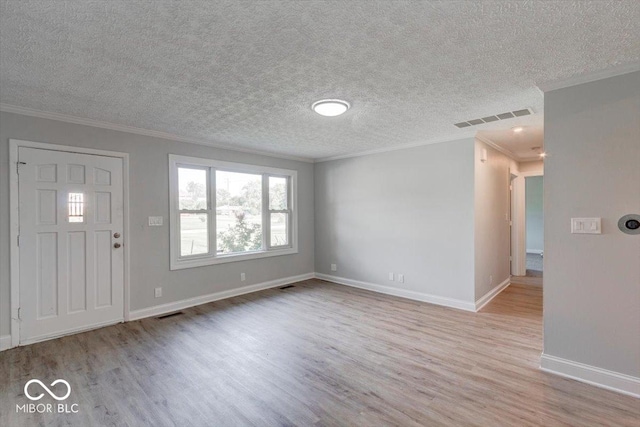 entryway featuring ornamental molding, a textured ceiling, and light wood-type flooring