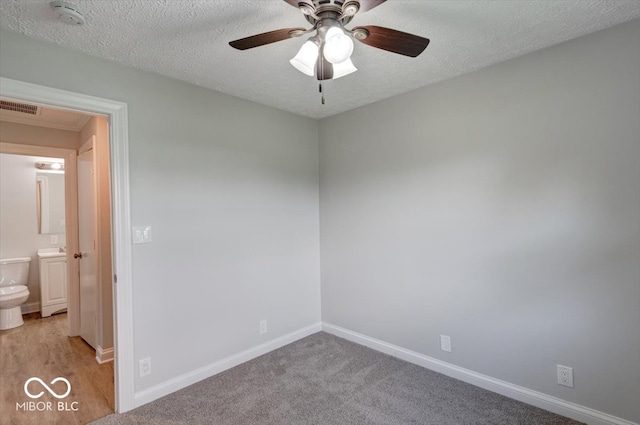 carpeted empty room with a textured ceiling and ceiling fan