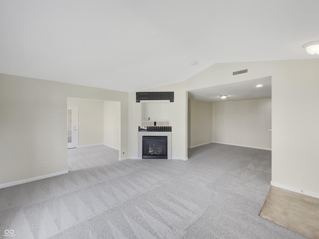 unfurnished living room with lofted ceiling and light colored carpet