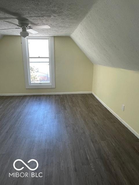 bonus room with dark hardwood / wood-style floors, ceiling fan, lofted ceiling, and a textured ceiling