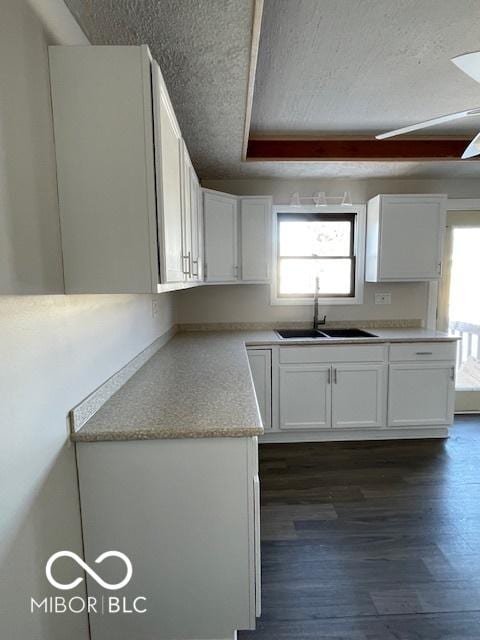 kitchen featuring a healthy amount of sunlight, white cabinetry, sink, and dark wood-type flooring