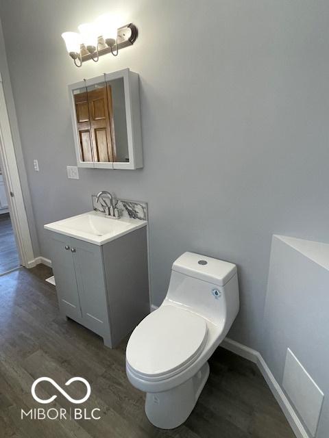 bathroom featuring vanity, toilet, and wood-type flooring