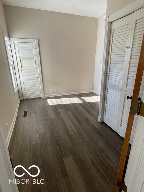 interior space with dark hardwood / wood-style floors and a closet