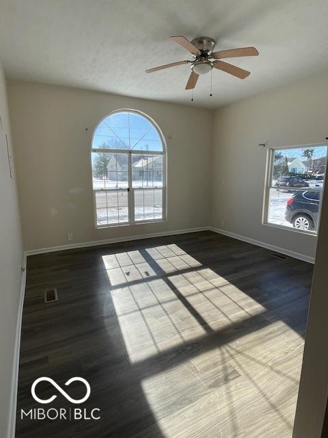 spare room featuring ceiling fan and dark wood-type flooring