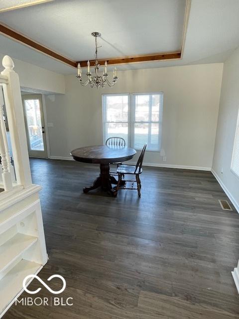 unfurnished dining area featuring an inviting chandelier, a raised ceiling, and dark hardwood / wood-style floors