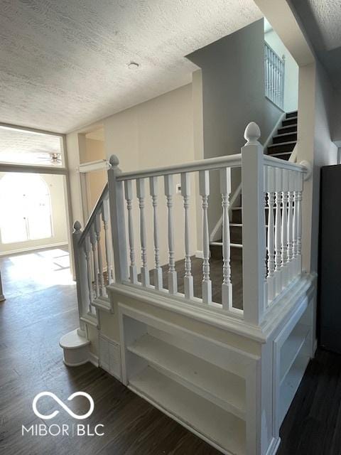 stairs featuring hardwood / wood-style flooring and a textured ceiling