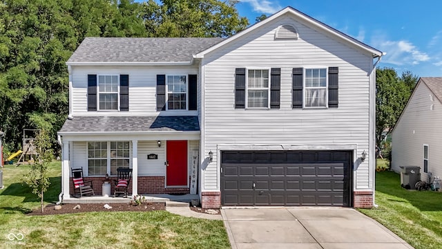 view of front of property featuring a porch, a front lawn, and a garage