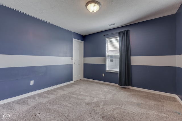 carpeted empty room with a textured ceiling