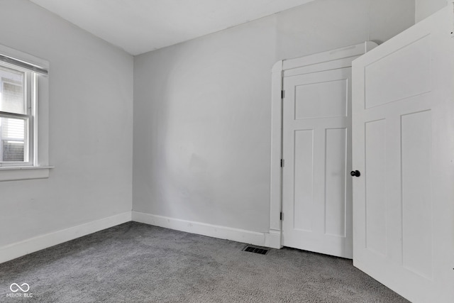 carpeted spare room featuring visible vents and baseboards