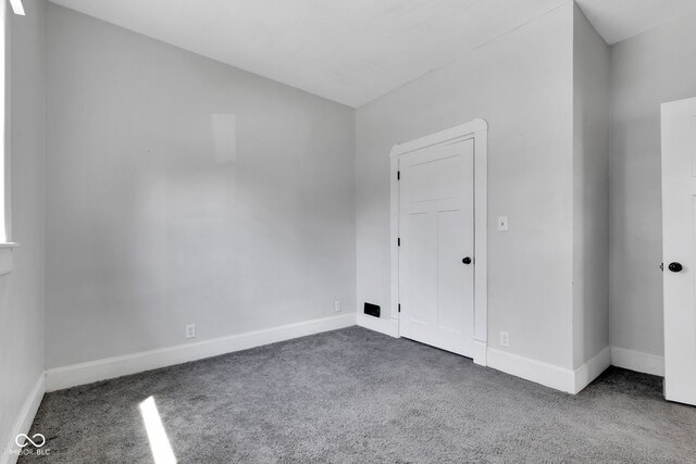 carpeted empty room with baseboards
