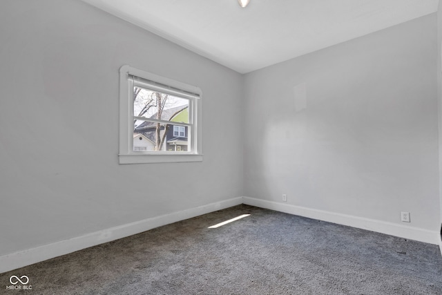 empty room featuring baseboards and carpet
