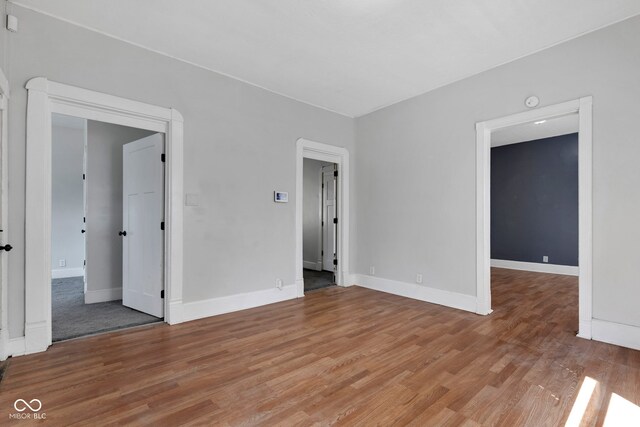 empty room featuring baseboards and light wood-type flooring