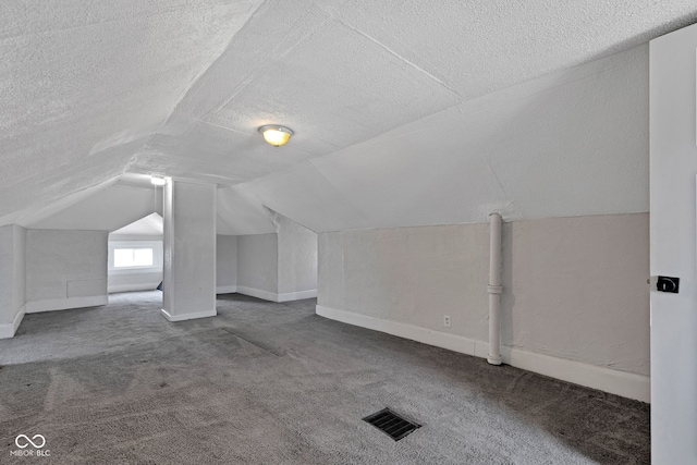 bonus room featuring visible vents, carpet flooring, lofted ceiling, and a textured ceiling