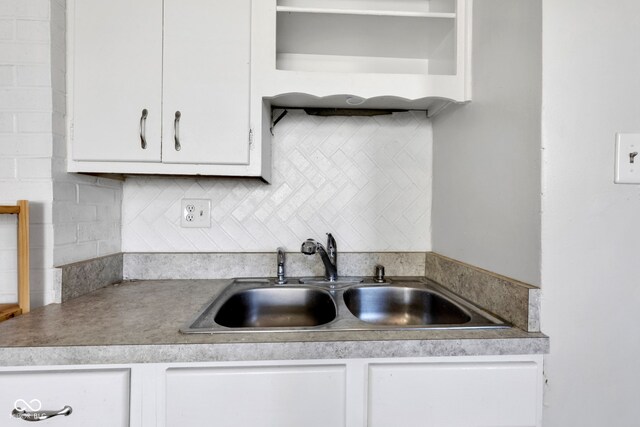 kitchen with white cabinets, a sink, and decorative backsplash