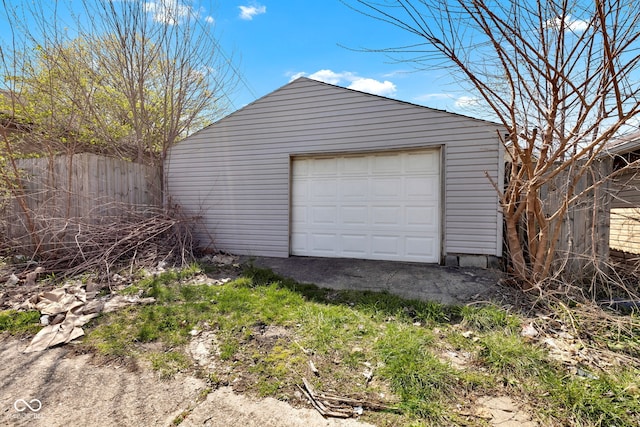 detached garage featuring fence