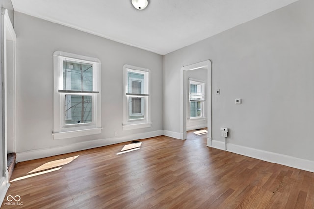 empty room with baseboards and wood finished floors