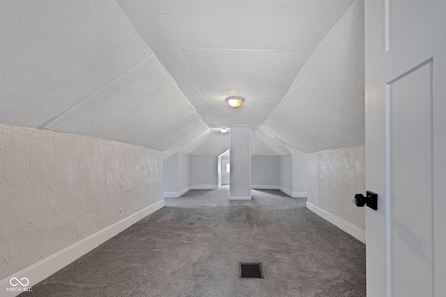 bonus room featuring carpet, a textured ceiling, visible vents, lofted ceiling, and baseboards