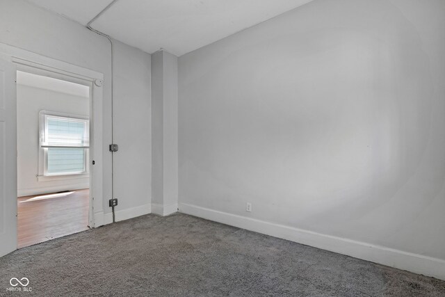 carpeted spare room featuring baseboards