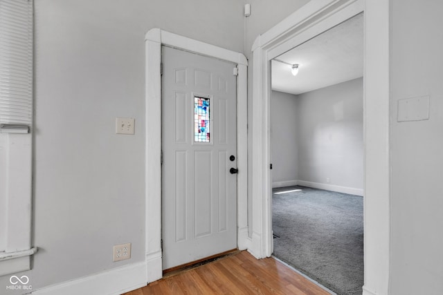foyer with baseboards and wood finished floors