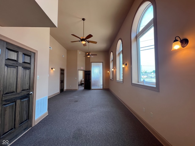 interior space featuring a high ceiling and ceiling fan