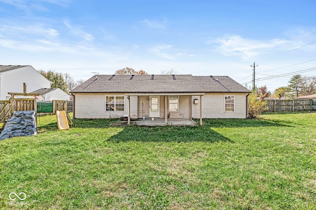 back of house featuring a playground, a yard, and a patio