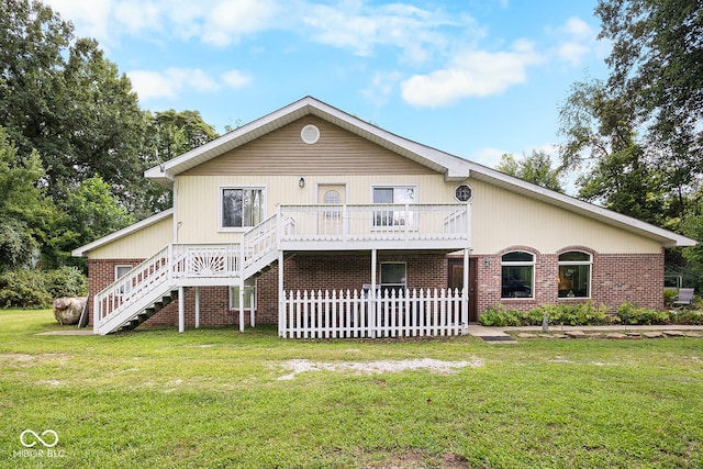 rear view of house with a yard and a deck