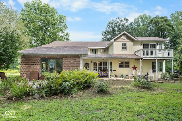 back of house featuring a yard and a balcony