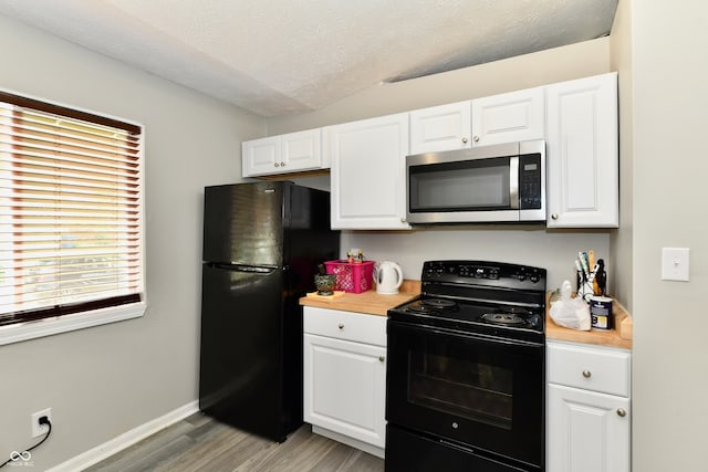 kitchen with a textured ceiling, light wood-type flooring, black appliances, and white cabinetry