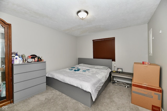 bedroom with light colored carpet and a textured ceiling