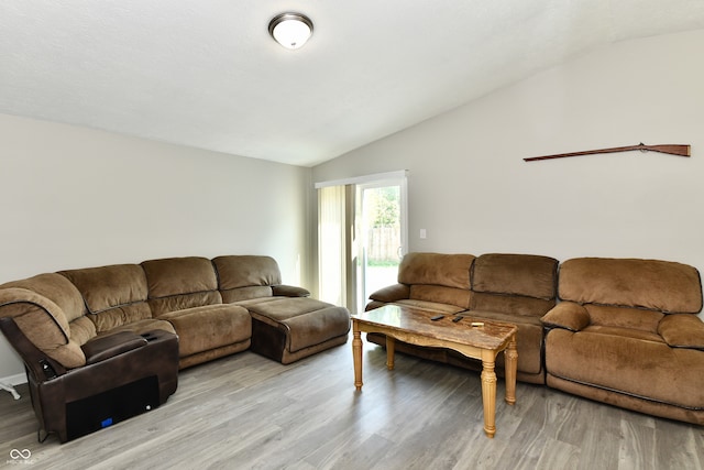 living room with light wood-type flooring and vaulted ceiling