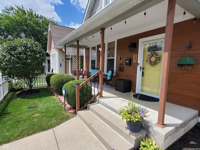 doorway to property featuring a yard and covered porch